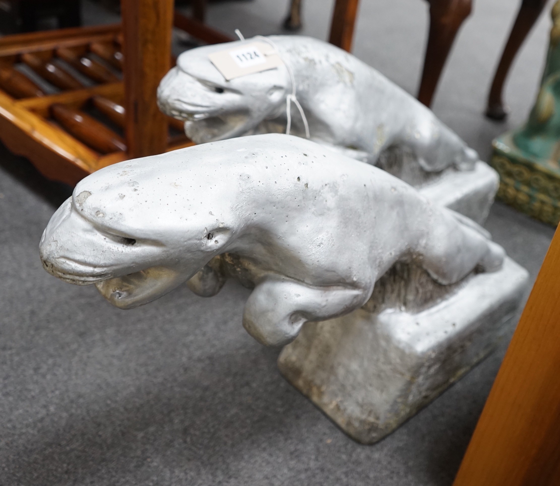 A pair of painted reconstituted stone Jaguars after F.G. Crosby by repute taken from a car dealership, circa 1930, length 60cm, height 36cm